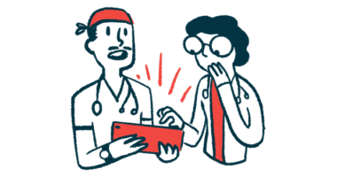 Two medical professionals look at a tablet one is holding, while talking.